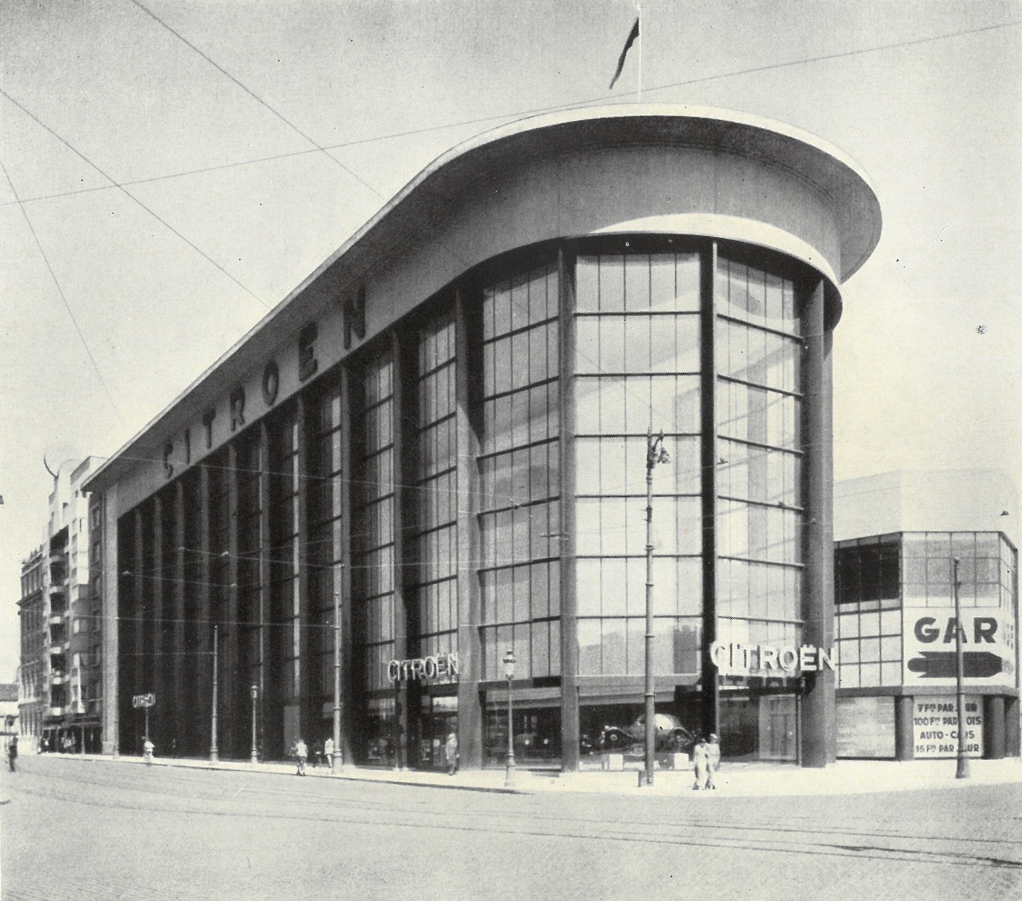Photo en noir et blanc de l'ancien siège Citroën à Bruxelles, bâtiment moderniste à l'angle arrondi et à la grande verrière, 1934